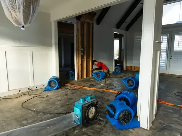 Air movers positioned across an open-plan room to dry the floor