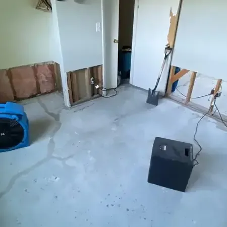 Air movers and a dehumidifier drying a room with lower drywall removed, Escondido water damage