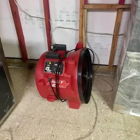 Red air mover and plastic sheeting at an opened lower wall for Encinitas drying
