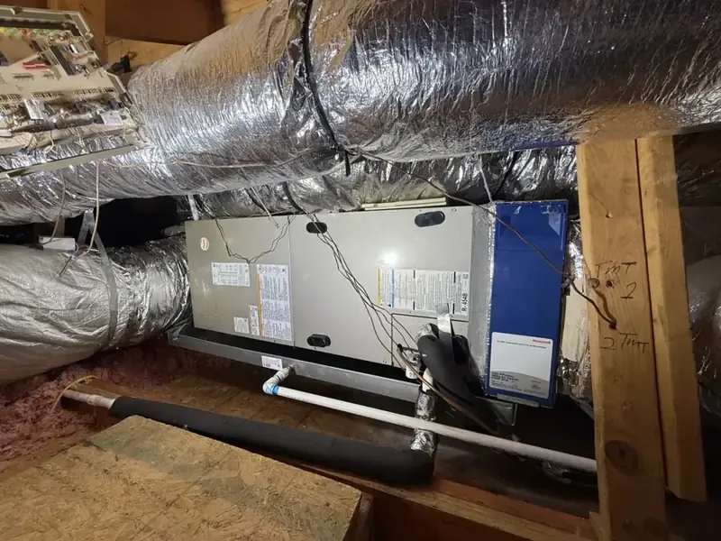 Attic air handler with its condensate drain line above a ceiling